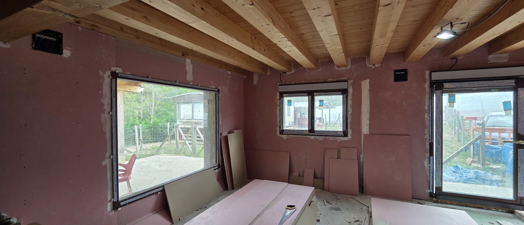 Instalación eléctrica en reforma integral de vivienda con paredes en obra y vigas de madera vista